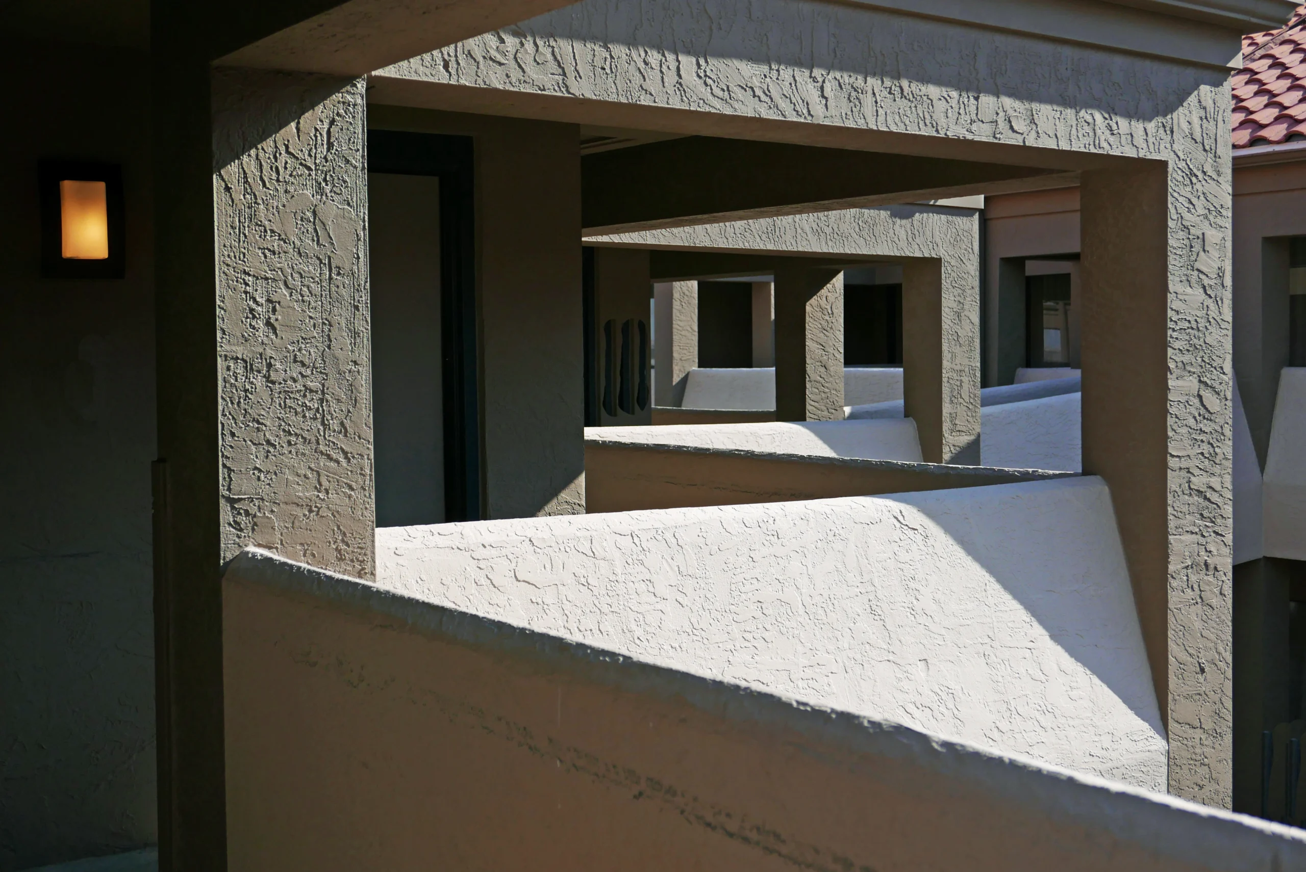 Textured stucco walls and balcony openings at a multi-story property